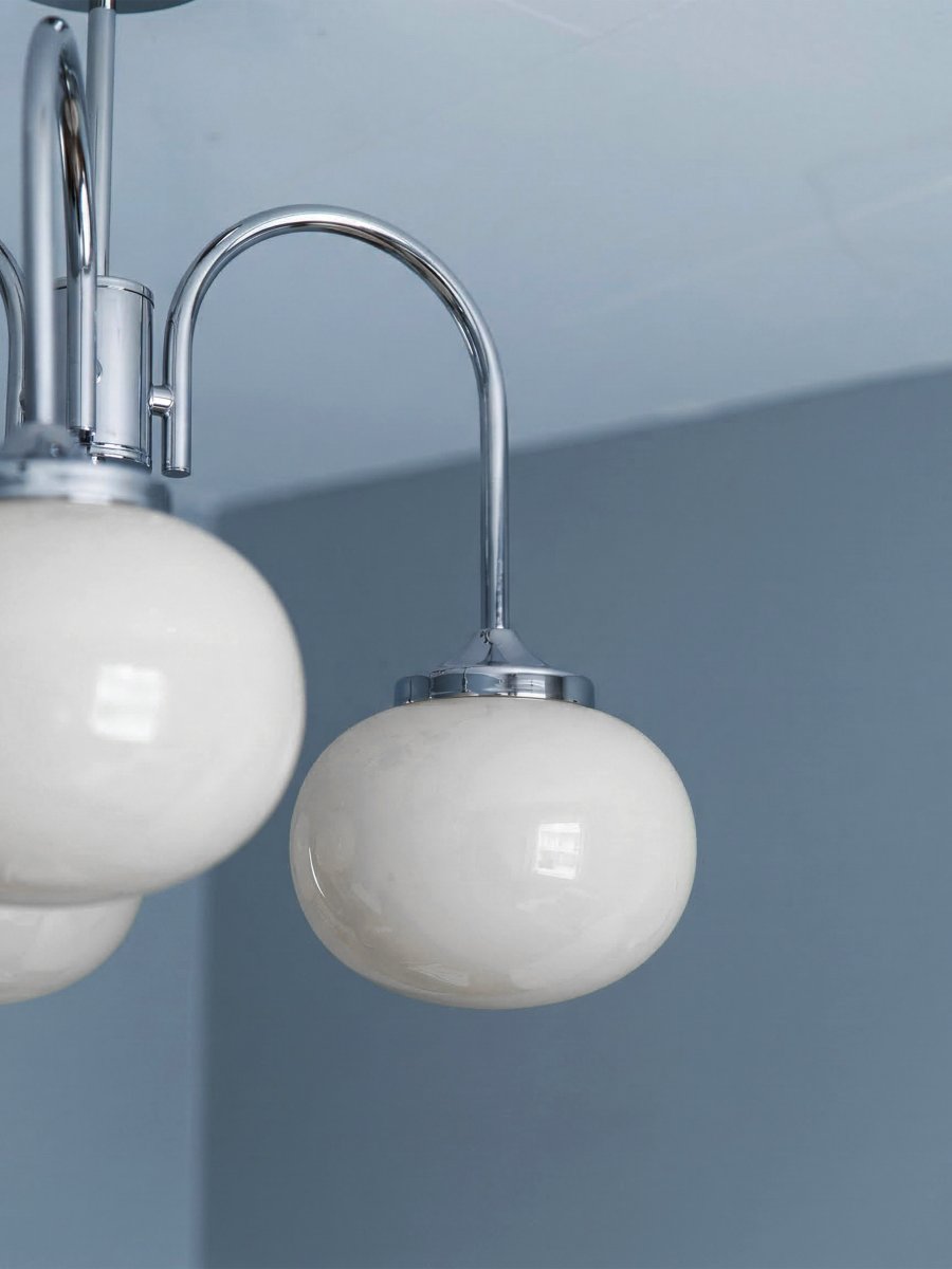 Elsy Ø52 Chrome plafonnier De PR Home - Il est dot&eacute; de trois bras orient&eacute;s vers le bas, surmont&eacute;s d'abat-jour en verre blanc qui diffusent une lumi&egrave;re douce et agr&eacute;able, cr&eacute;ant une ambiance cosy dans les salons, salles &agrave; manger ou couloirs.