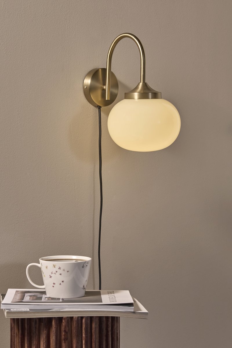 Elsy 30cm Laiton brossé lampe de lecture De PR Home - Son abat-jour en verre soufflé à la main, d'un blanc crème doux, confère à chaque lampe un caractère unique, tandis que les détails en laiton brossé créent un contraste raffiné et exclusif.