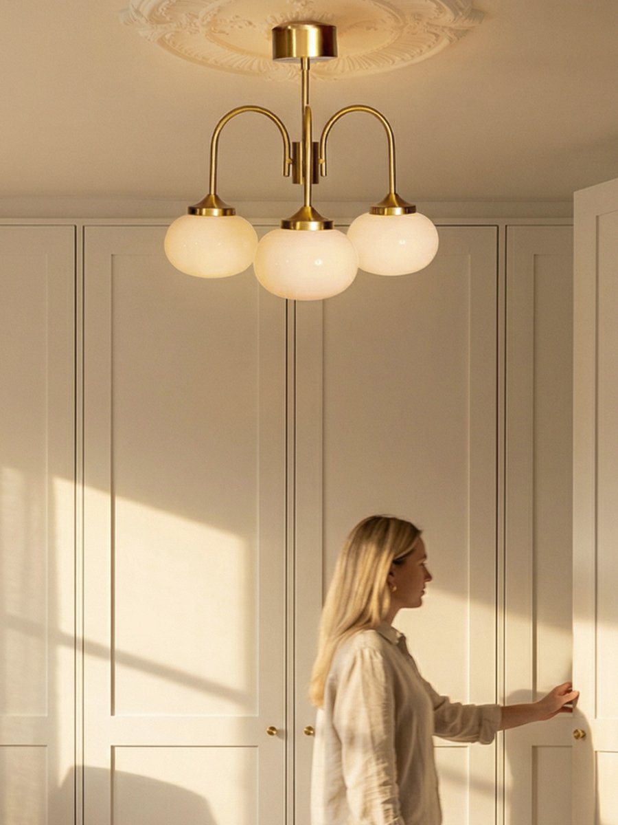 Elsy Ø52 Laiton brossé plafonnier De PR Home - Ses trois bras orient&eacute;s vers le bas, coiff&eacute;s d'abat-jour en verre cr&egrave;me, diffusent une douce lueur agr&eacute;able, cr&eacute;ant une ambiance cosy, par exemple dans un salon, une salle &agrave; manger ou un couloir.