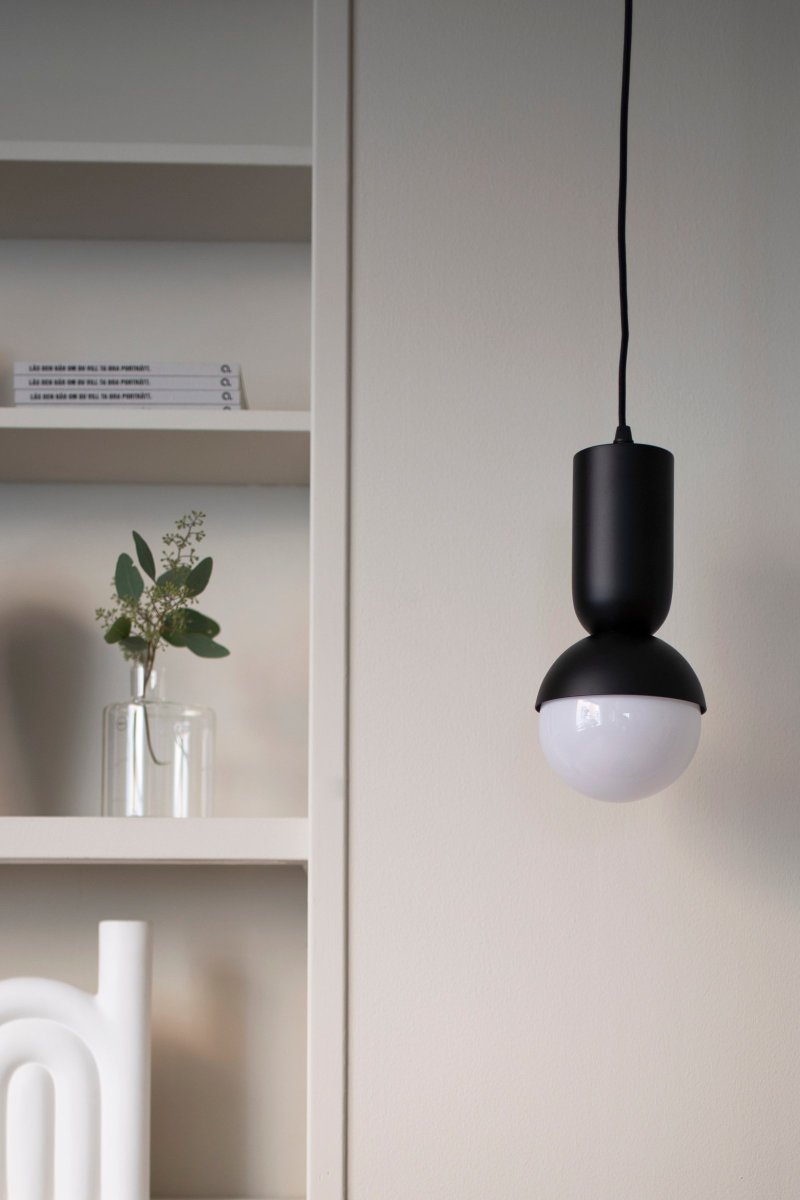 Nero Ø13 Noir suspension De Globen Lighting - D&egrave;s le d&eacute;but, la lampe Nero &eacute;tait une tentative de combiner une sph&egrave;re avec une forme tubulaire ovale.