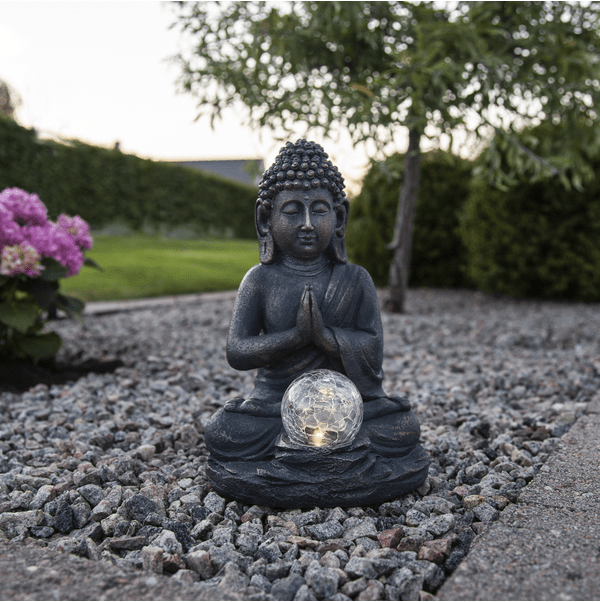 Buddha Gris lampe solaire De Star Trading - La sph&egrave;re transparente sur le devant diffuse une douce lumi&egrave;re blanche chaude au cr&eacute;puscule, cr&eacute;ant une atmosph&egrave;re harmonieuse.