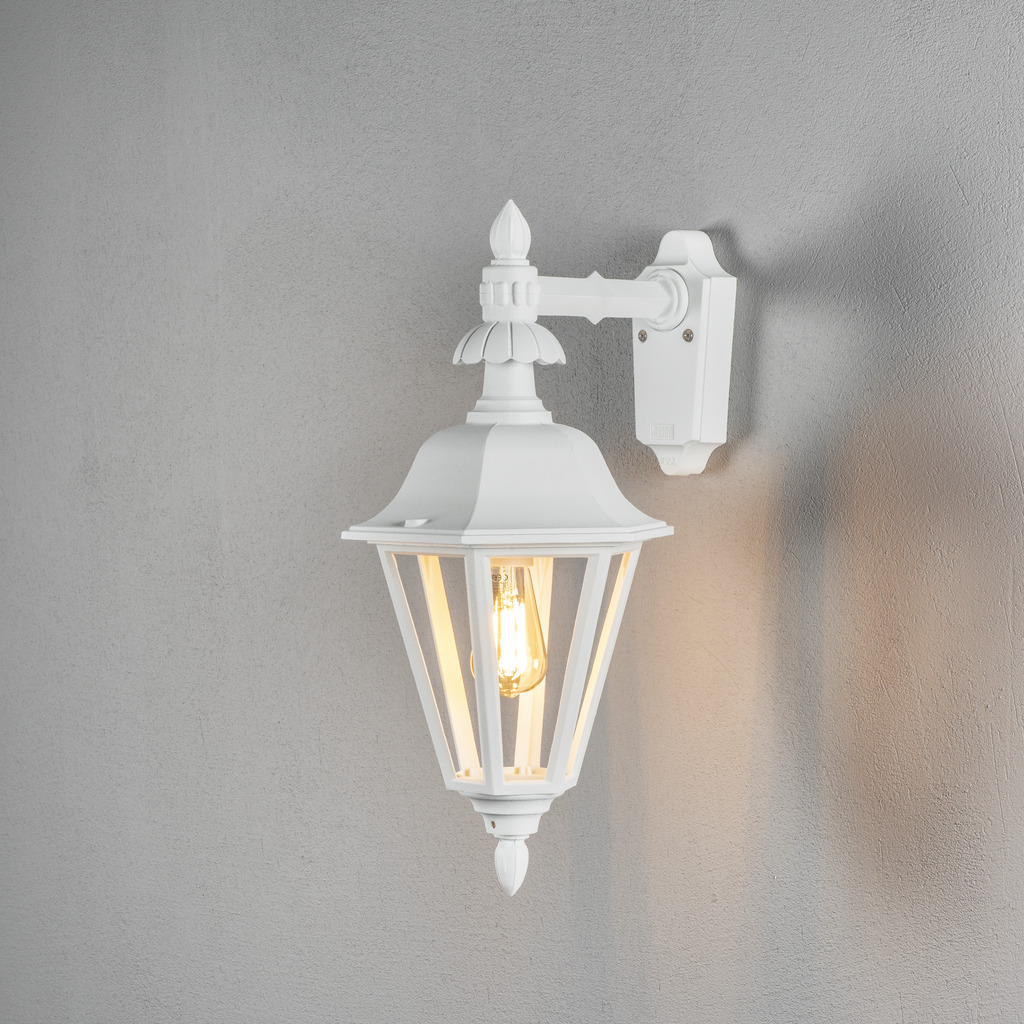 Pallas Blanc lampe d’extérieur De Konstsmide - Avec sa conception en forme de lanterne et ses panneaux en verre transparent, la lampe émet une lumière chaleureuse et invitante, parfaite pour les entrées, les patios et les allées.