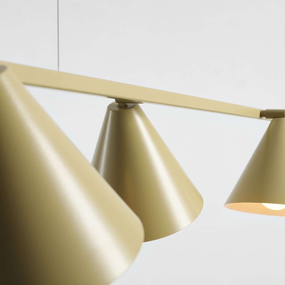 Form 120cm Pistache suspension De Artera - Sa forme allongée s'harmonise parfaitement avec ses quatre abat-jour coniques d'un doux vert pistache, conférant à la lumière un caractère à la fois moderne et décoratif.