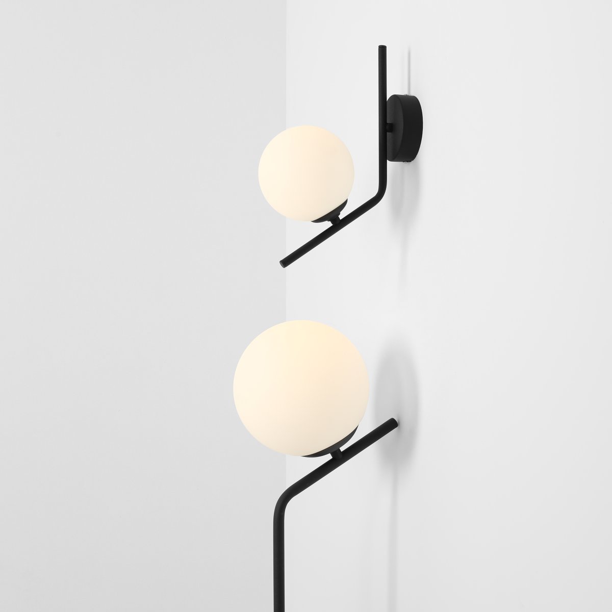 Gallia Ø14 Noir applique murale De Artera - Avec un cadre noir et un globe opale rond, la lampe fournit une lumi&egrave;re douce et diffuse qui cr&eacute;e une atmosph&egrave;re chaleureuse et accueillante dans la pi&egrave;ce.