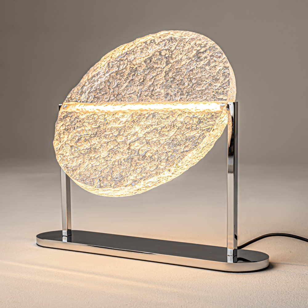 Mangata 30cm Transparent lampe de table De Maytoni - Son pied en m&eacute;tal chrom&eacute; lui conf&egrave;re un style &eacute;l&eacute;gant et exclusif, tandis que son abat-jour en acrylique transparent &agrave; la surface textur&eacute;e diffuse la lumi&egrave;re de mani&egrave;re d&eacute;corative.