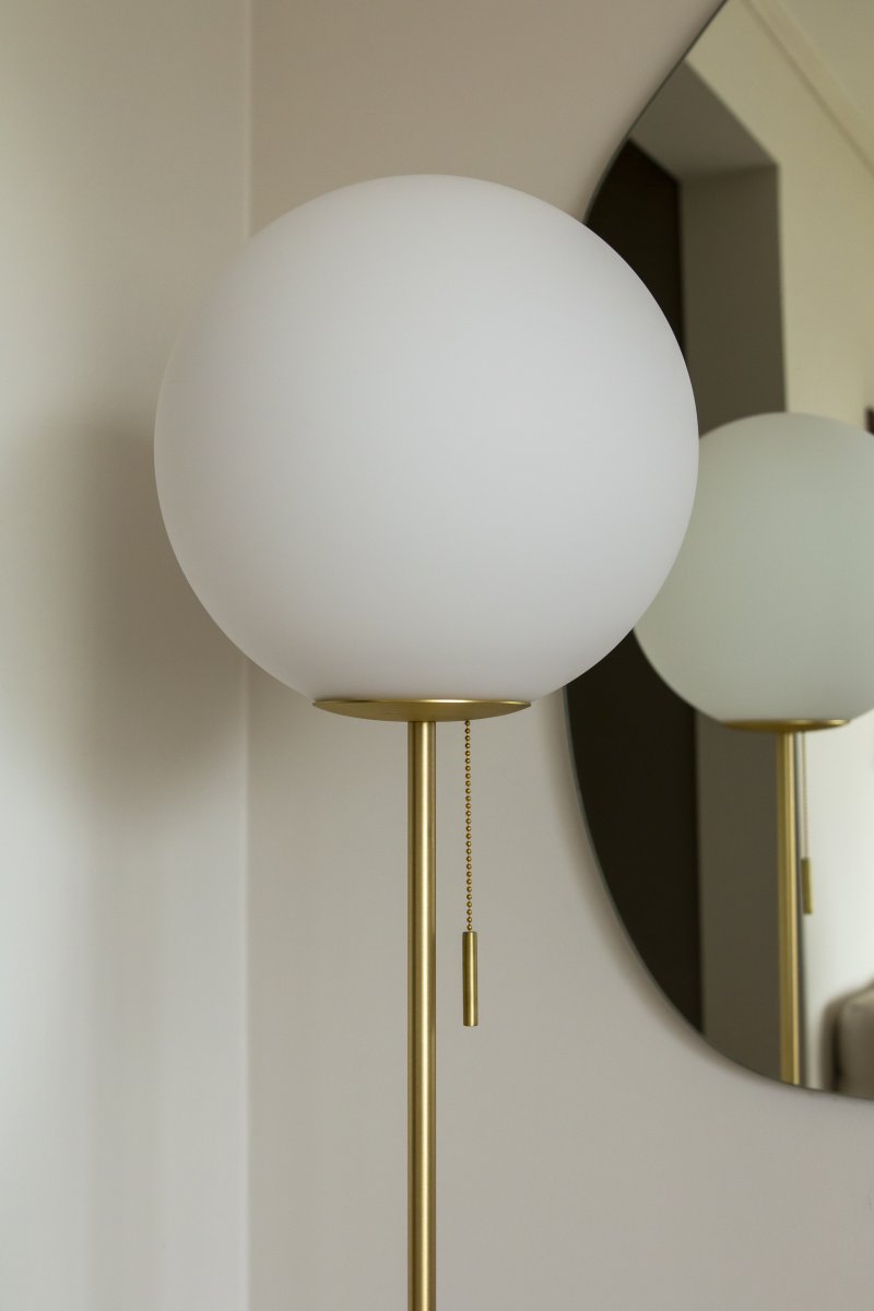 Torrano Travertin beige lampadaire De Globen Lighting - Torrano est dotée d'un pied en pierre solide et élégante, de détails métalliques et d'un abat-jour en verre blanc mat.