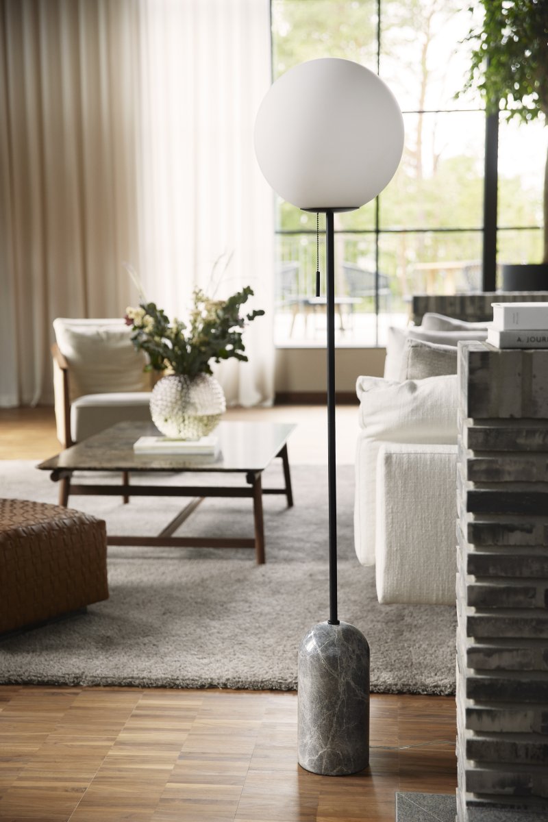 Torrano Marbre gris lampadaire De Globen Lighting - Torrano est dotée d'un pied en pierre solide et élégante, de détails métalliques et d'un abat-jour en verre blanc mat.