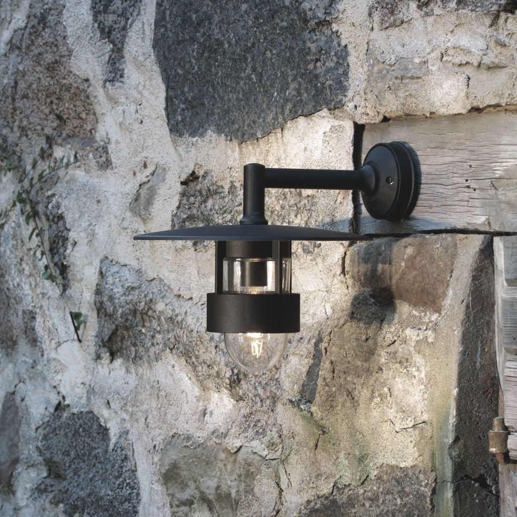 Freja Noir lampe d’extérieur De Konstsmide - La lampe diffuse une lumière agréable à travers les détails en verre et possède un large abat-jour qui protège des éléments, la rendant à la fois durable et fonctionnelle.