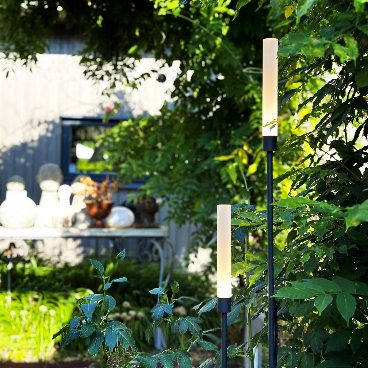 Frost Gris foncé De Lightson - Frost &auml;r ett elegant set av tv&aring; ljuspelare i m&ouml;rkgr&aring; aluminium som f&ouml;rvandlar dina utomhusmilj&ouml;er med sitt varma, mjuka ljus.