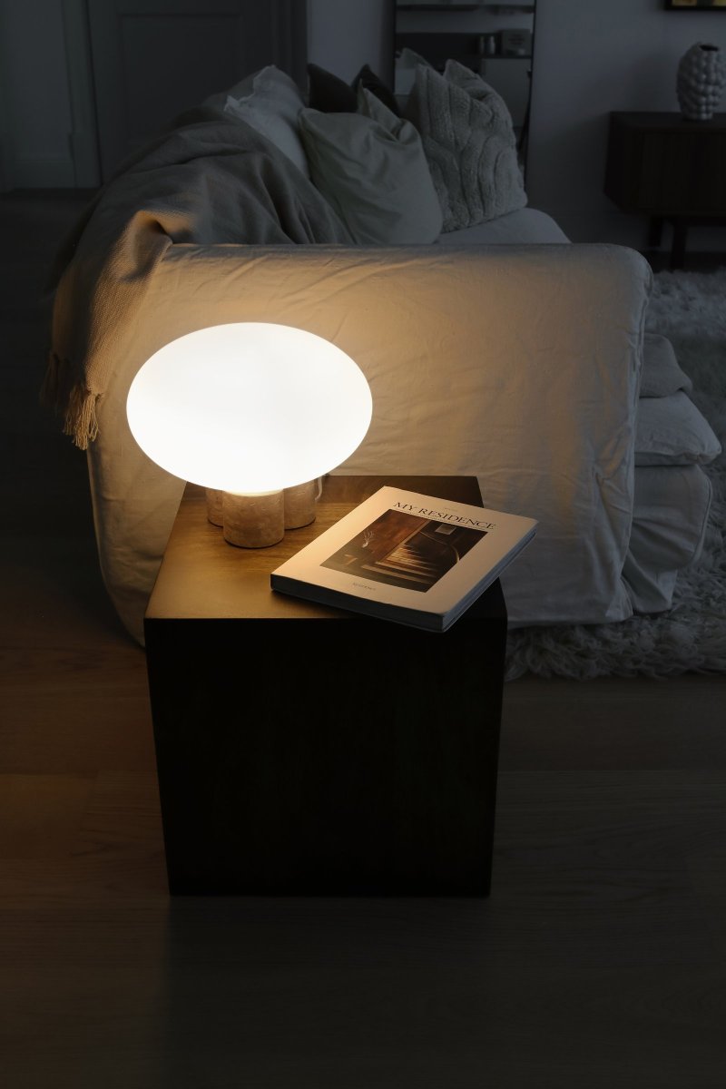 Mammut 25cm Travertin lampe de table De Globen Lighting - La base de la lampe est équipée d'un abat-jour rond en verre blanc mat et aplati de taille légèrement surdimensionnée, ce qui crée une expression ludique.