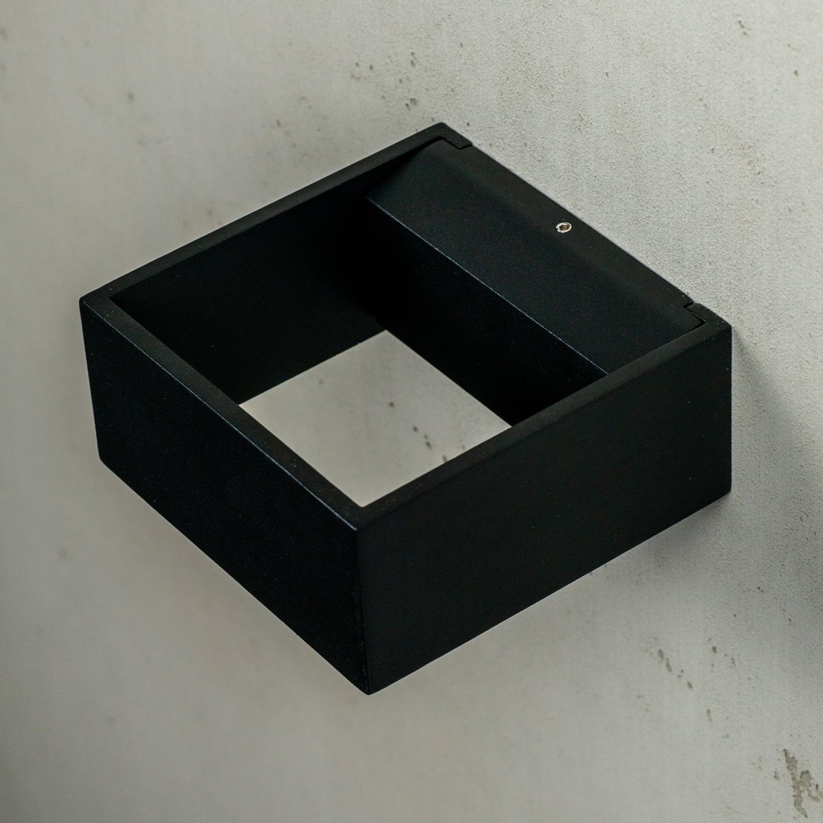 Jupiter Noir lampe d’extérieur De Dyberg Larsen - Jupiter a un côté plat sur le mur et une face avant semi-circulaire avec une source de lumière LED qui brille de haut en bas le long du mur.