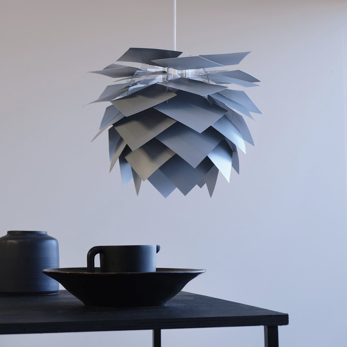 Illumin Ø45 Gris suspension De Dyberg Larsen - La lampe est livrée dans une élégante boîte avec un cadre de lampe, 40 feuilles qui forment l'abat-jour, un câble en tissu de 3 mètres de long et notre capuchon de plafond Rosetta unique, qui convient à toutes les pentes de plafond jusqu'à 45 degrés.