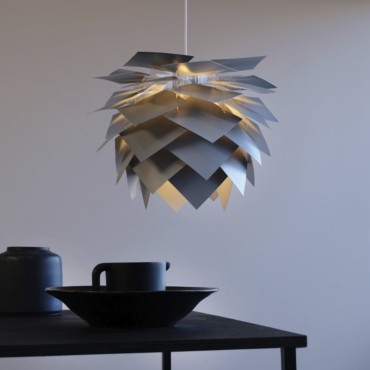 Illumin Ø45 Gris suspension De Dyberg Larsen - La lampe est livrée dans une élégante boîte avec un cadre de lampe, 40 feuilles qui forment l'abat-jour, un câble en tissu de 3 mètres de long et notre capuchon de plafond Rosetta unique, qui convient à toutes les pentes de plafond jusqu'à 45 degrés.