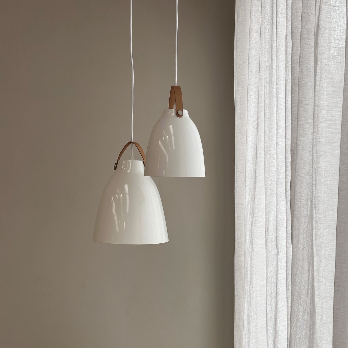 Copenhagen Ø19 Blanc brillant suspension De Dyberg Larsen - Fabriquée en métal et dotée d'une sangle en cuir droite sur l'abat-jour, la lampe donne une expression unique et personnelle.