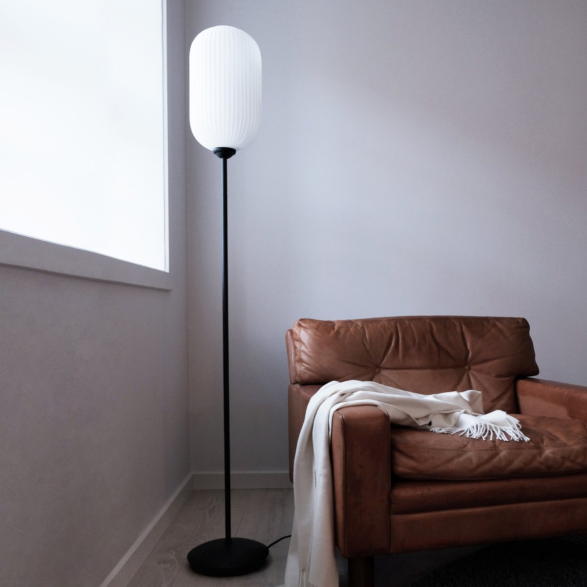 Riflet Noir lampadaire De Dyberg Larsen - Le lampadaire Riflet de Dyberg Larsen a un nouveau design avec un abat-jour en verre opale magnifiquement nervuré qui crée une lumière douce et agréable.