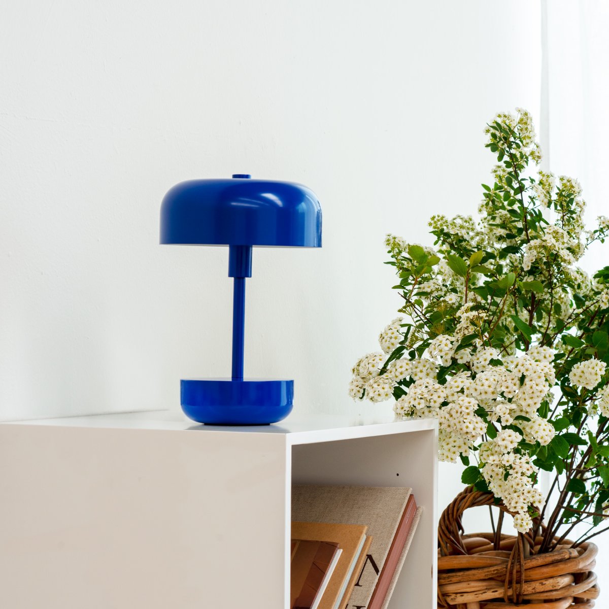 Haipot 25cm Bleu portable De Dyberg Larsen - La conception ouverte de l'abat-jour assure une belle réflexion de la lumière qui met en valeur la couleur de la base, et lorsque l'obscurité tombe, la lampe crée un jeu de lumière atmosphérique.
