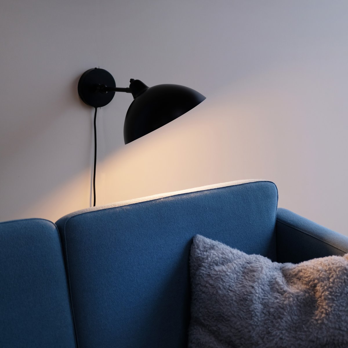 Futura 43cm Noir applique murale De Dyberg Larsen - Il est fait de métal avec un extérieur noir et un intérieur blanc, créant un look minimaliste.