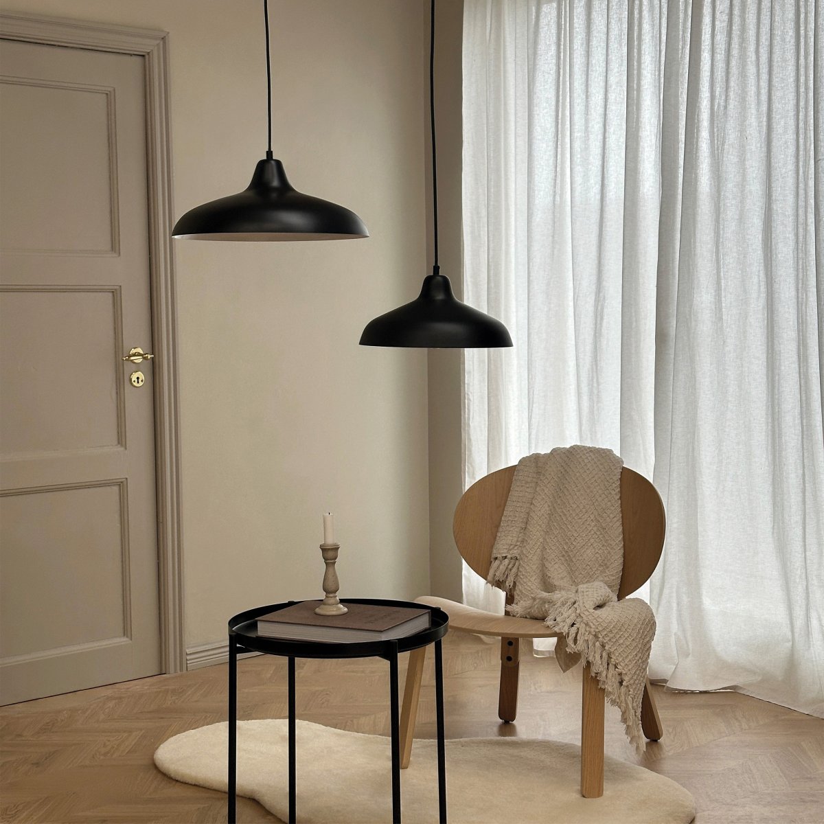 Futura Ø40 Noir suspension De Dyberg Larsen - Il est fait de métal avec un extérieur noir et un intérieur blanc, créant un look minimaliste.
