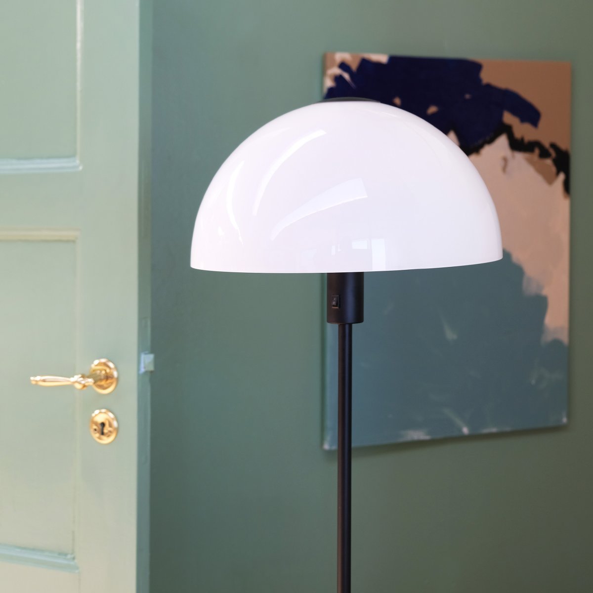 Jazz Noir lampadaire De Dyberg Larsen - Lampadaire en verre blanc opale avec une base en métal noir mat.
