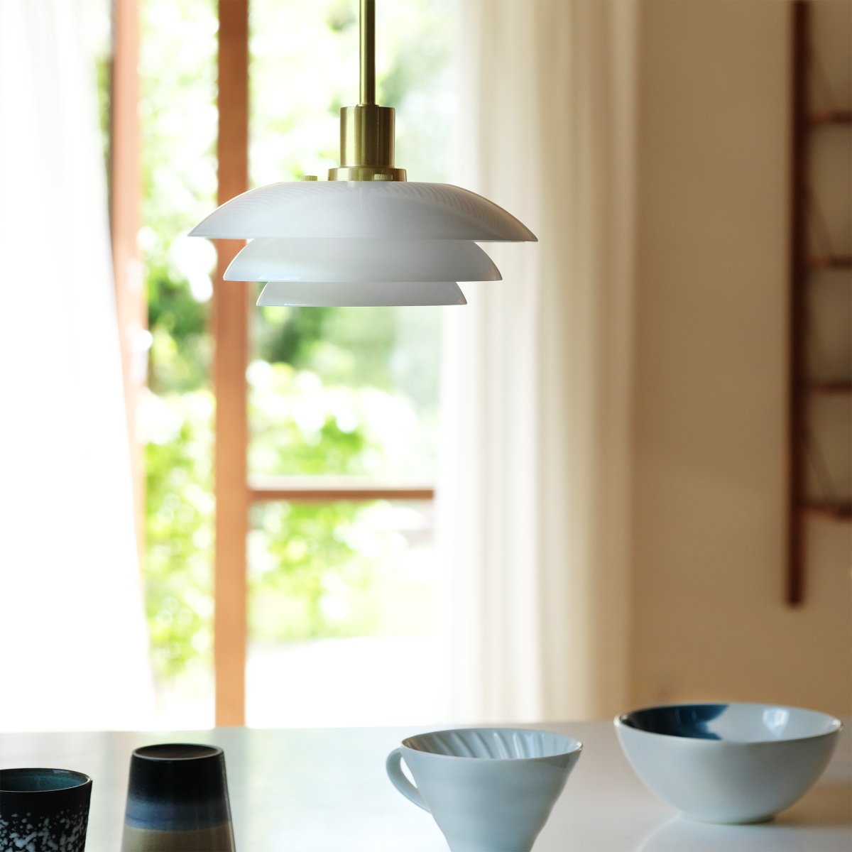 DL20 Ø20 Laiton suspension De Dyberg Larsen - La suspension opale DL20 avec une base en métal laiton est une lampe élégante qui s'intègre parfaitement au-dessus de la table à manger ou de la table basse.