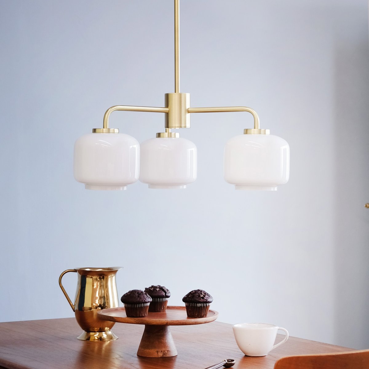 Arp Ø54 Laiton suspension De Dyberg Larsen - Avec trois abat-jour en verre opale et une suspension en laiton mat, le lustre diffuse une lumière douce et agréable.