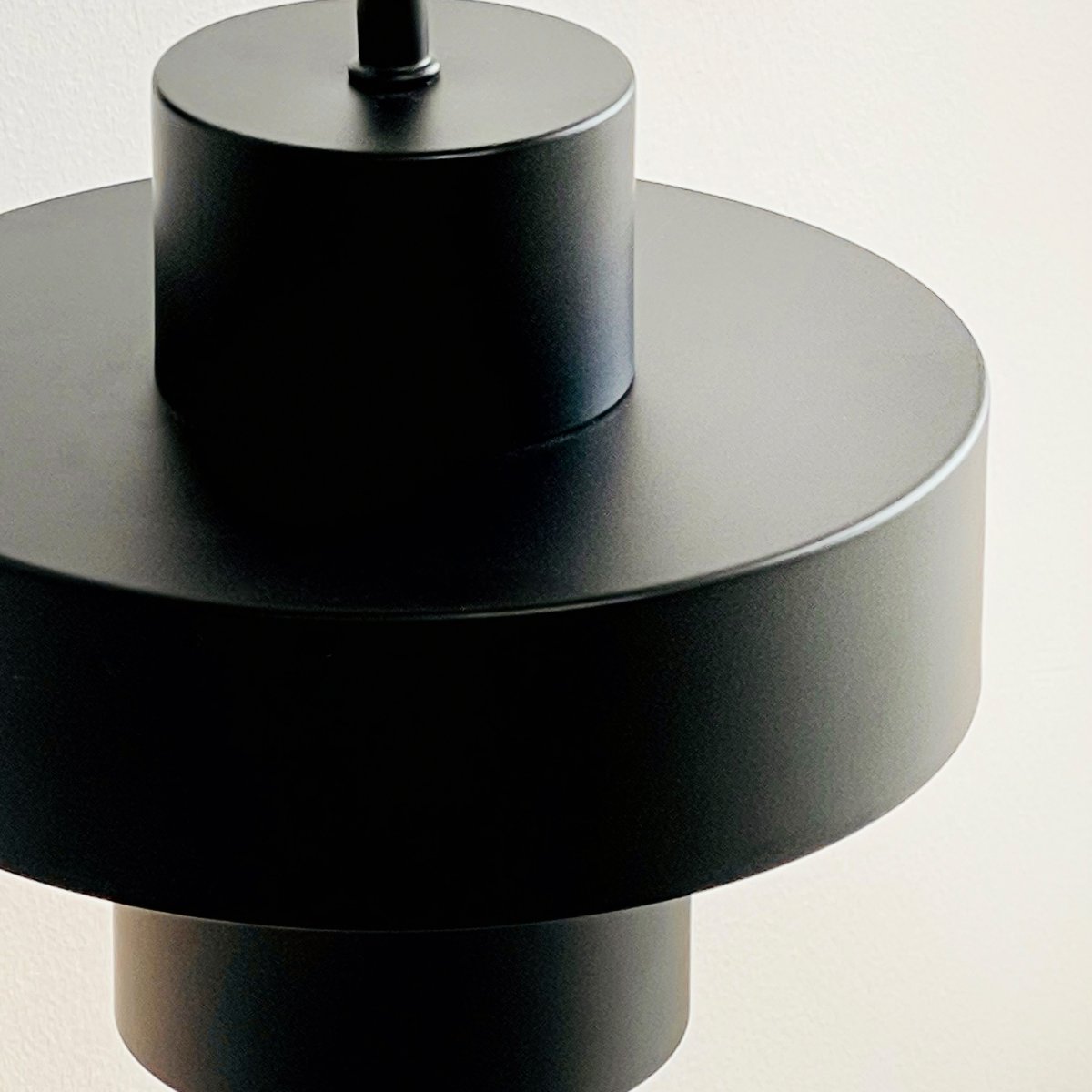 Stoke Ø15 Noir applique murale De Dyberg Larsen - Il est fabriqué en métal avec une finition mate qui met en valeur les formes cylindriques de la lampe et crée un contraste équilibré avec d'autres matériaux tels que la pierre, le bois et le verre.