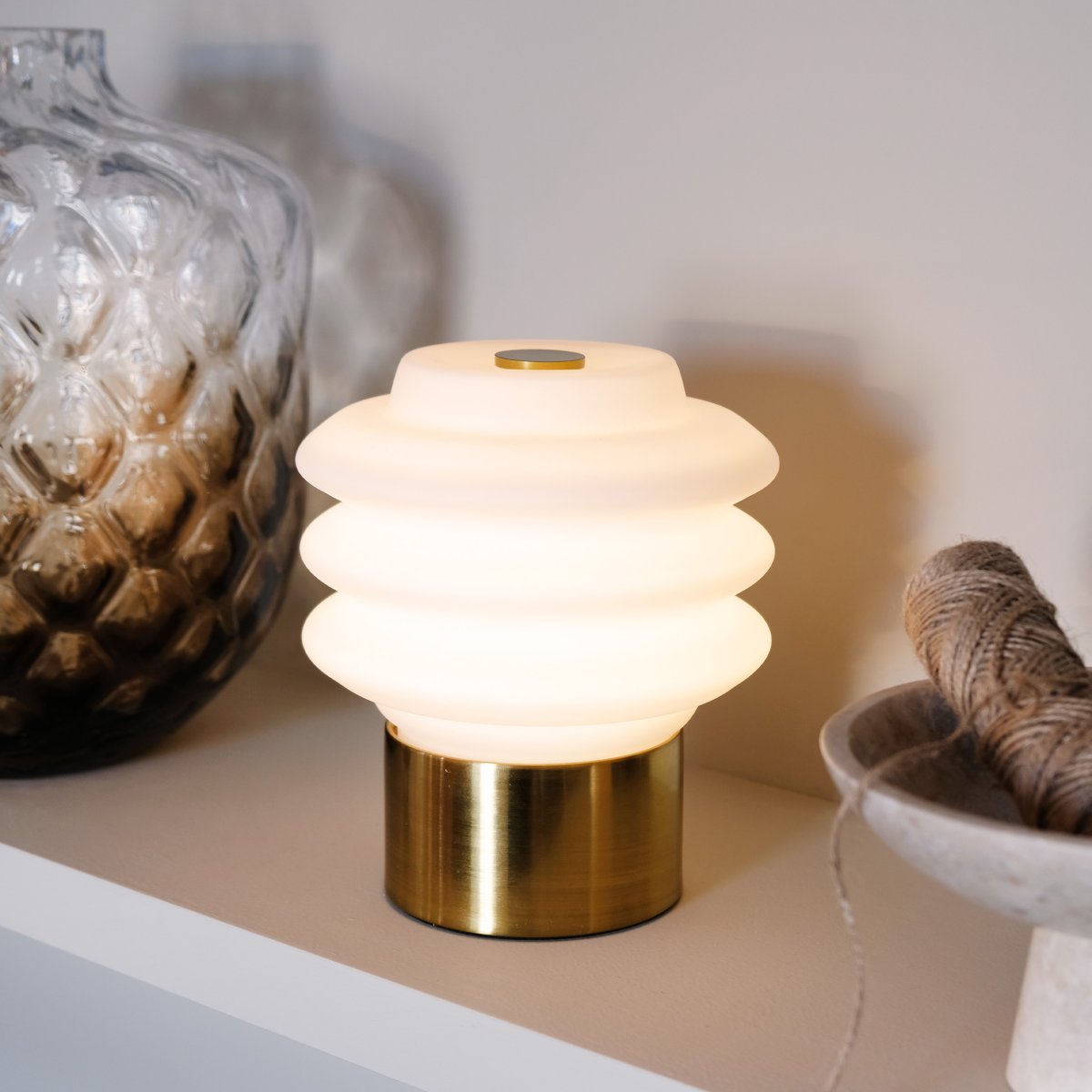 Diva LED 18cm Laiton portable De Dyberg Larsen - Tillverkad av opalglas ger den ett mjukt, behagligt sken, och den inbyggda LED-tekniken g&ouml;r den energieffektiv och h&aring;llbar.