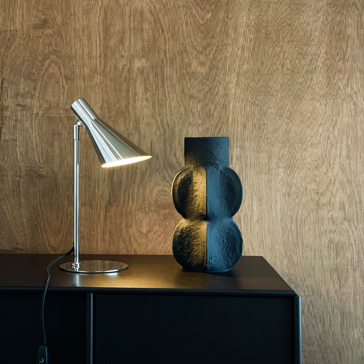 DL12 Mini 40cm Chrome lampe de bureau De Dyberg Larsen - Avec ses lignes graphiques distinctives et sa silhouette épurée, elle est idéale sur un bureau ou comme lampe de lecture dans le salon ou la chambre.