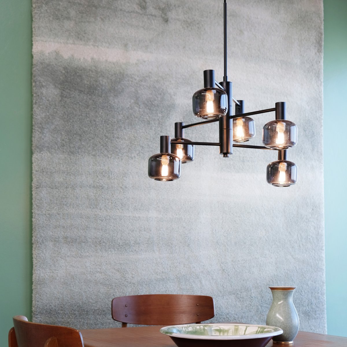 Arp Ø50 Noir suspension De Dyberg Larsen - Créez l'équilibre parfait entre forme et fonction avec le lustre Arp, doté de 6 magnifiques abat-jour en verre fumé et d'une élégante suspension noire.