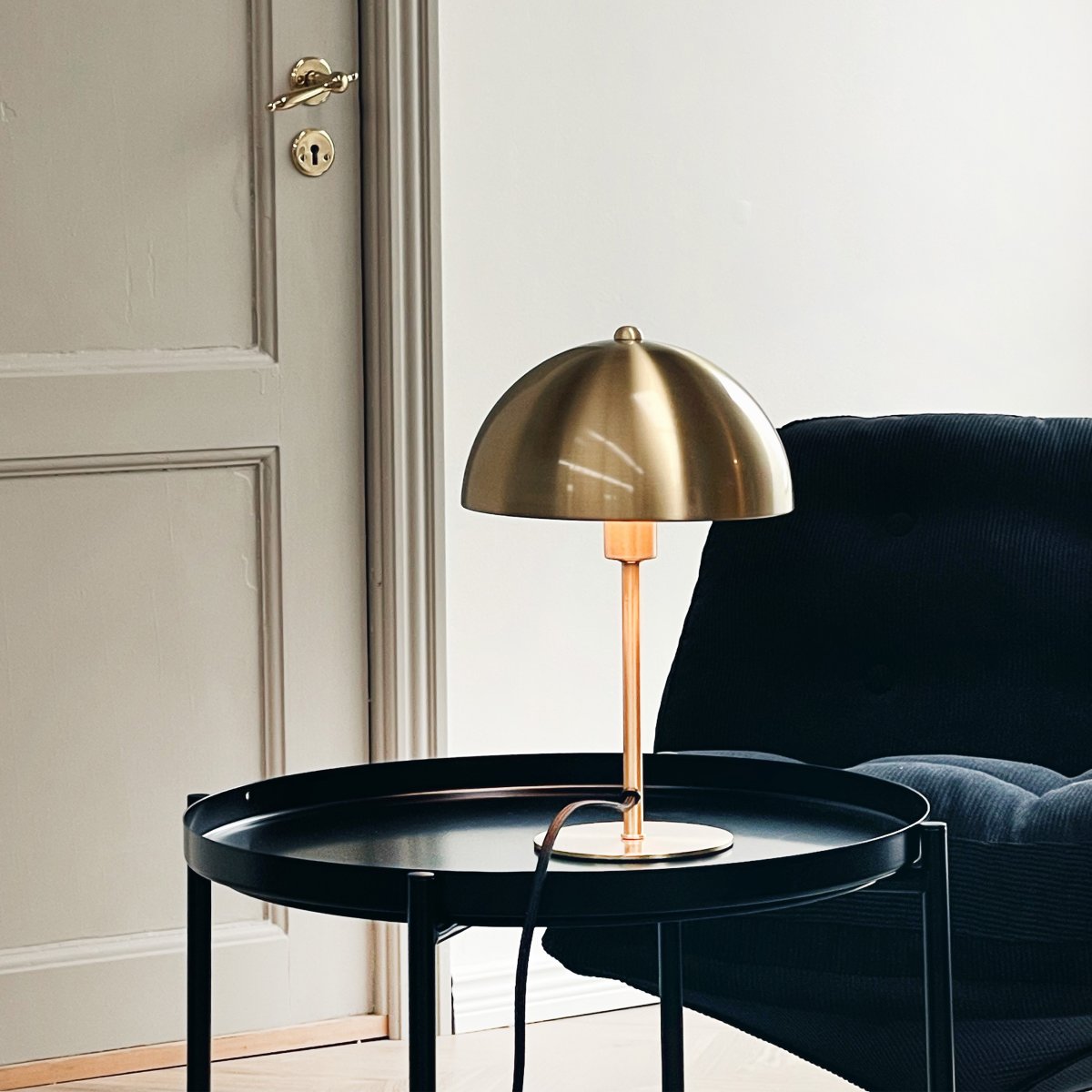 Lyon 30cm Laiton lampe de table De Dyberg Larsen - L'abat-jour semi-circulaire ajoute une touche moderne et assure une répartition lumineuse agréable et uniforme, idéale pour l'éclairage de travail et d'ambiance.
