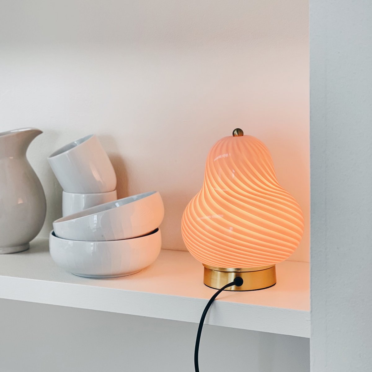 Lucy 20cm Rose lampe de table De Dyberg Larsen - La lampe en forme d'ampoule lui confère un aspect charmant et accrocheur, tandis que l'élégante base en laiton ajoute une sensation de luxe.