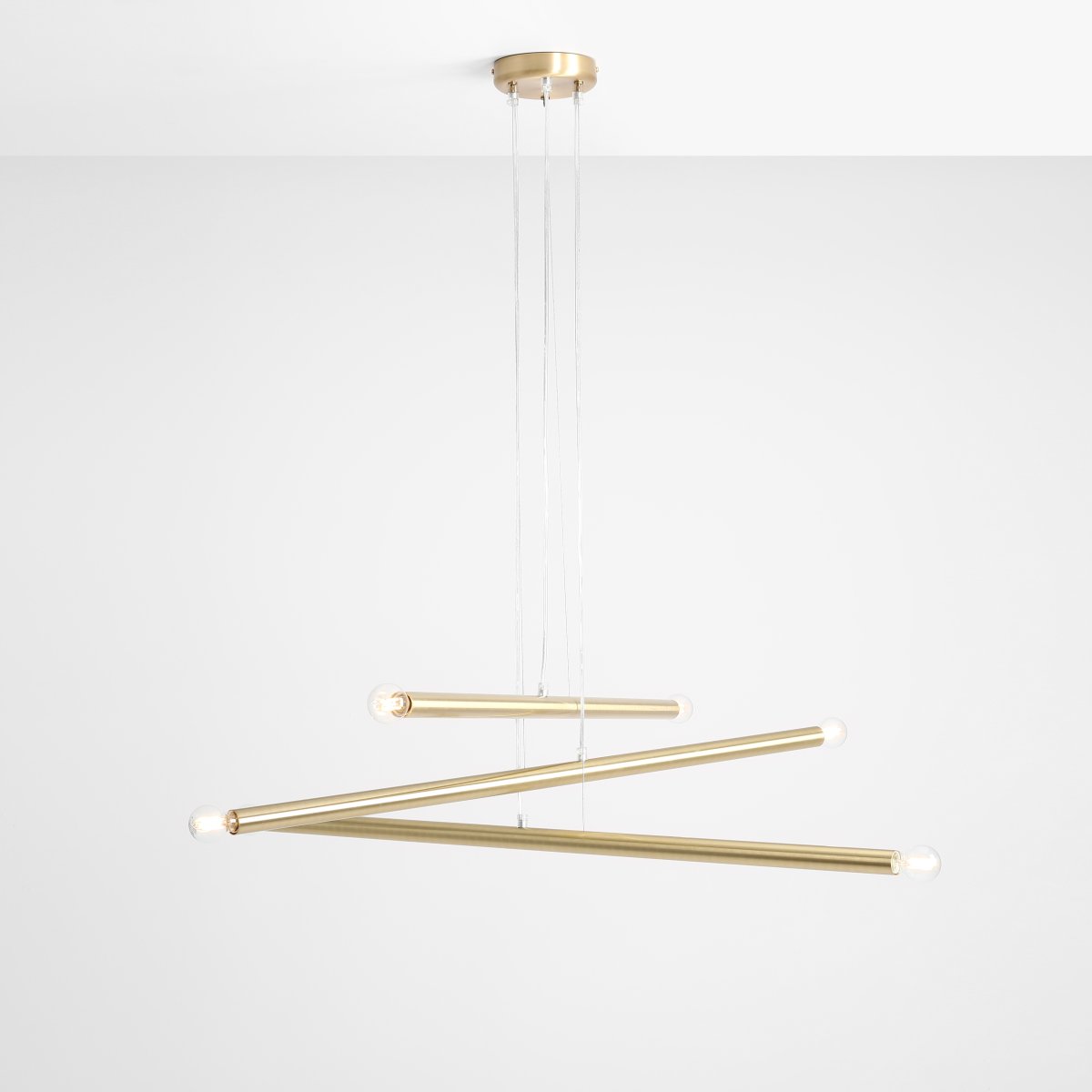 Tubo 6 100cm Laiton suspension De Artera - Elle se compose de trois fins tubes métalliques à la finition laiton élégante, disposés à différentes hauteurs et angles pour créer un effet dynamique et aérien.