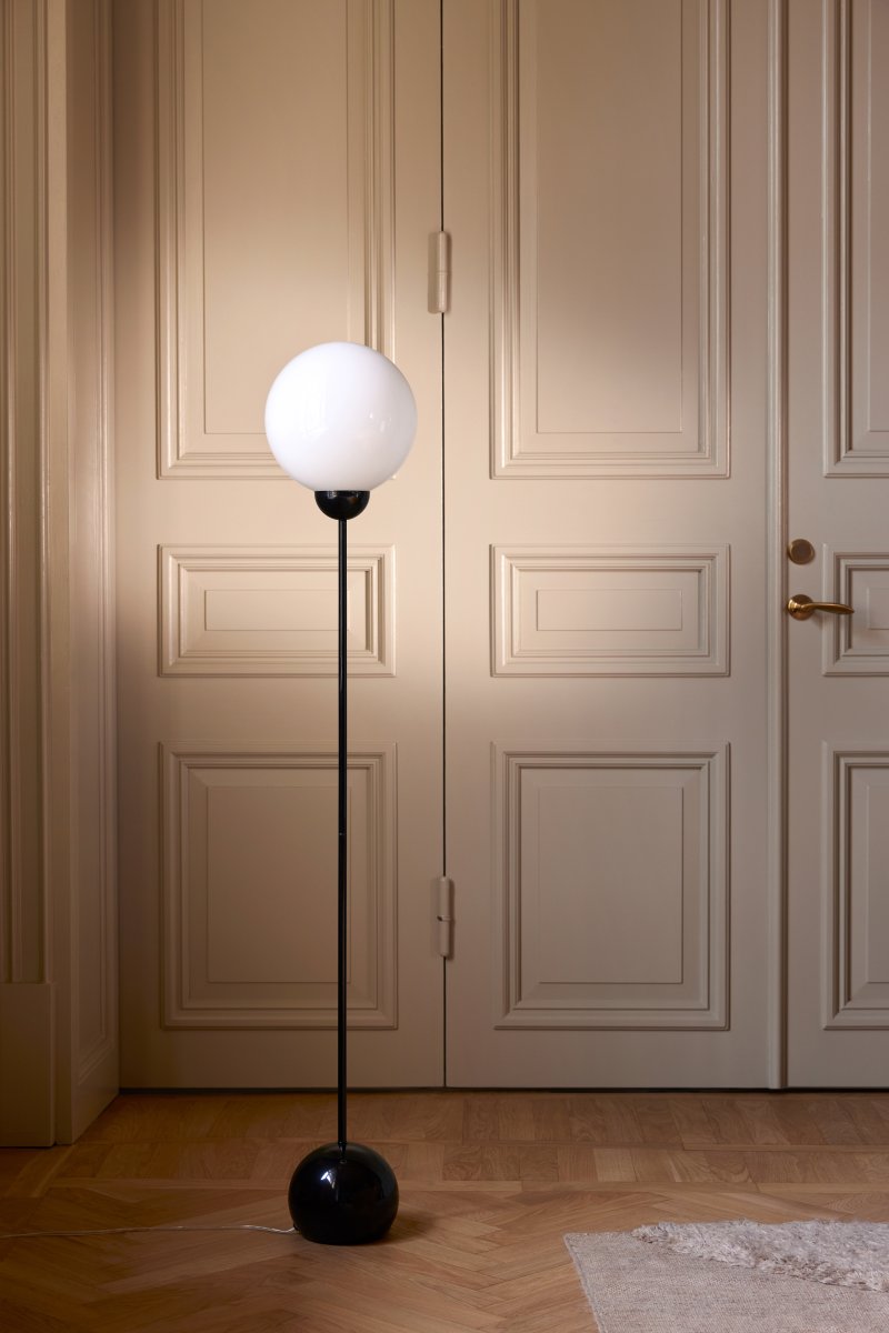 Ripley Noir lampadaire De Globen Lighting - Fabriquée en métal, cette lampe possède un dôme en verre blanc opale qui diffuse une lumière agréable.