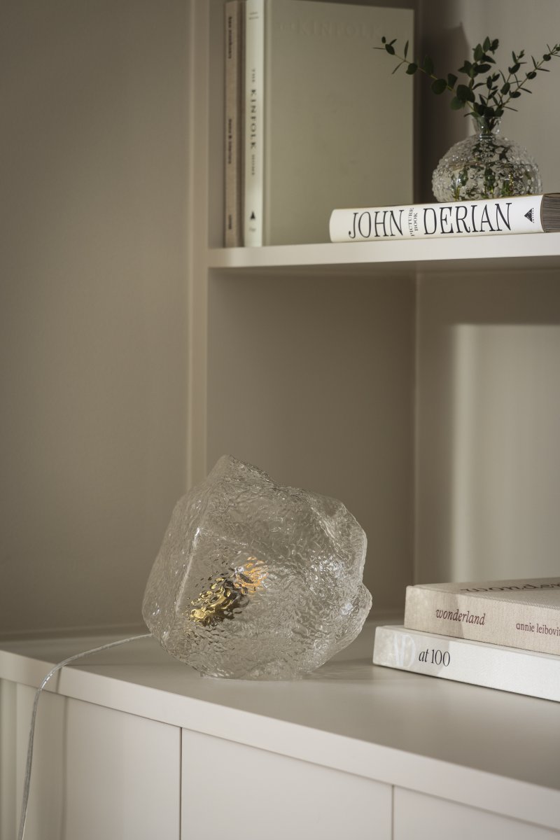 Valerie 22cm Transparent lampe de table De Globen Lighting - Le verre souffl&eacute; &agrave; la main, avec sa surface textur&eacute;e, capture la lumi&egrave;re, cr&eacute;ant un jeu de lumi&egrave;re vibrant.