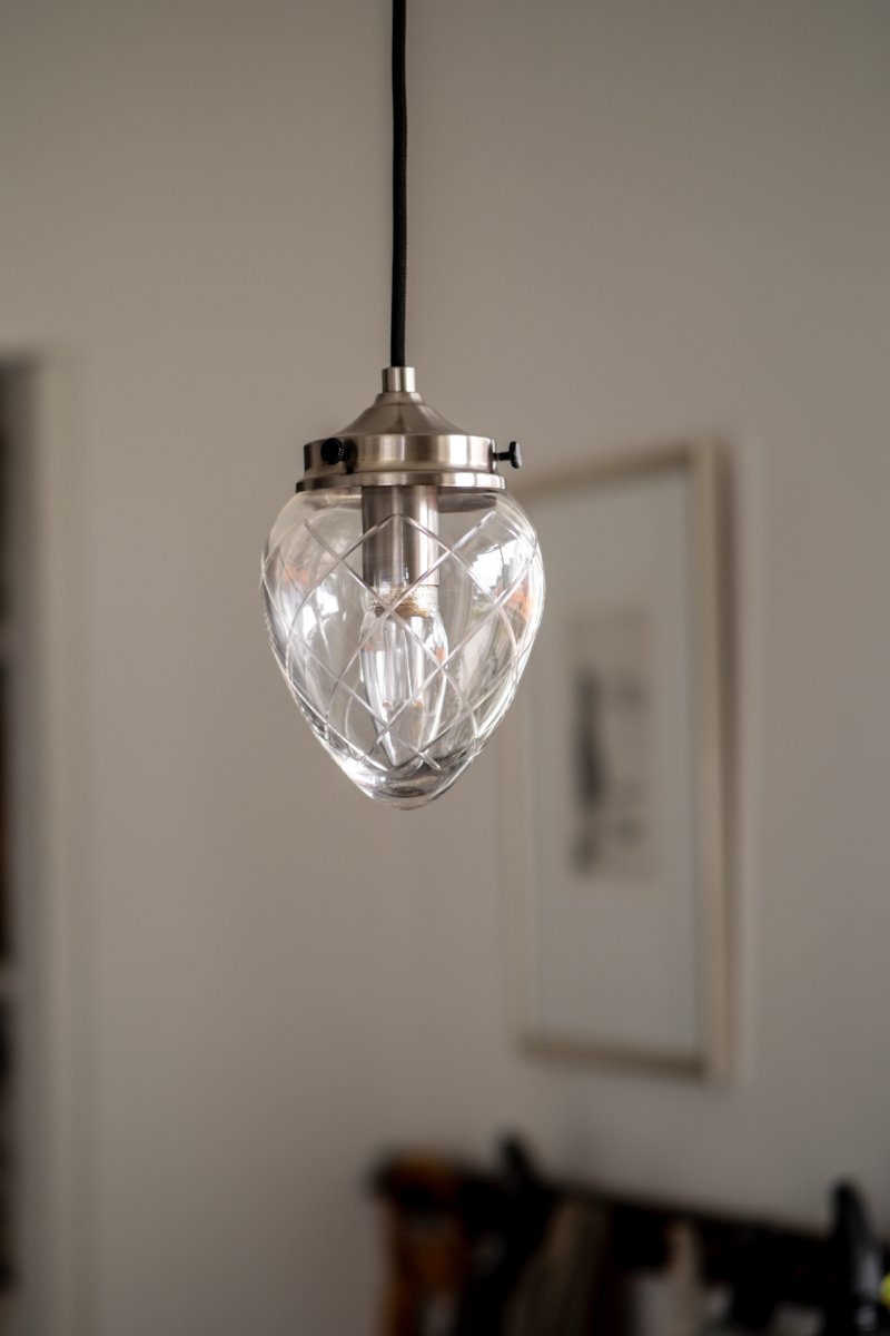 Juni Ø10 Acier antique/transparent lampe de fenêtre De Globen Lighting - Juni, avec son magnifique abat-jour en verre taillé et en métal, vous transporte au début du XXe siècle.