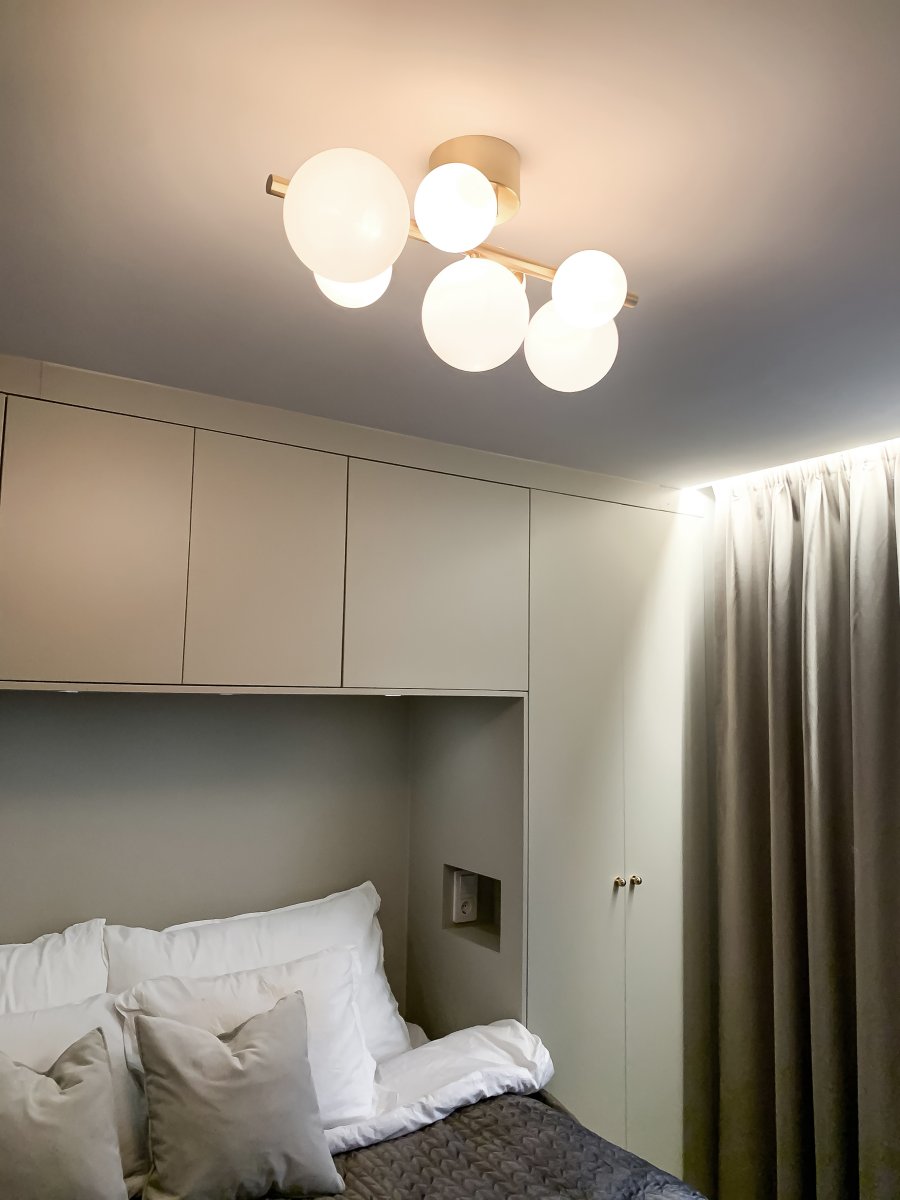 Molekyl 58cm Laiton mat plafonnier De Aneta Lighting - Plafonnier tendance de Molekyl en laiton mat avec 7 abat-jour en verre blanc opale de différentes tailles, monté sur une tige de 58 cm de long.