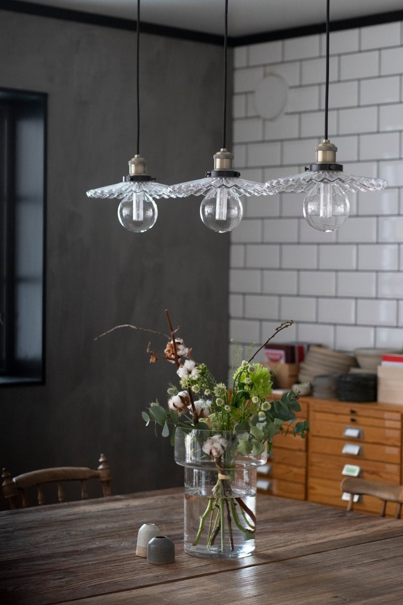 Cobbler 90cm Clair suspension De Globen Lighting - La lampe est dotée de trois câbles textiles noirs réglables en hauteur de 120 cm de long et d'un auvent de plafond en métal noir.