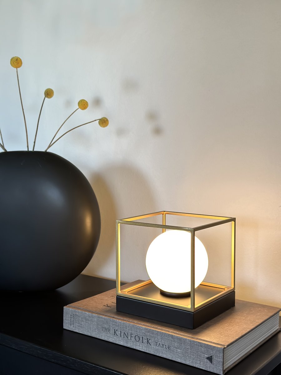 Astro 15cm Noir lampe de table De Aneta Lighting - Lampe de table Astro en métal laqué noir avec un dôme en verre blanc opale, encadrée de détails dorés sur la base.