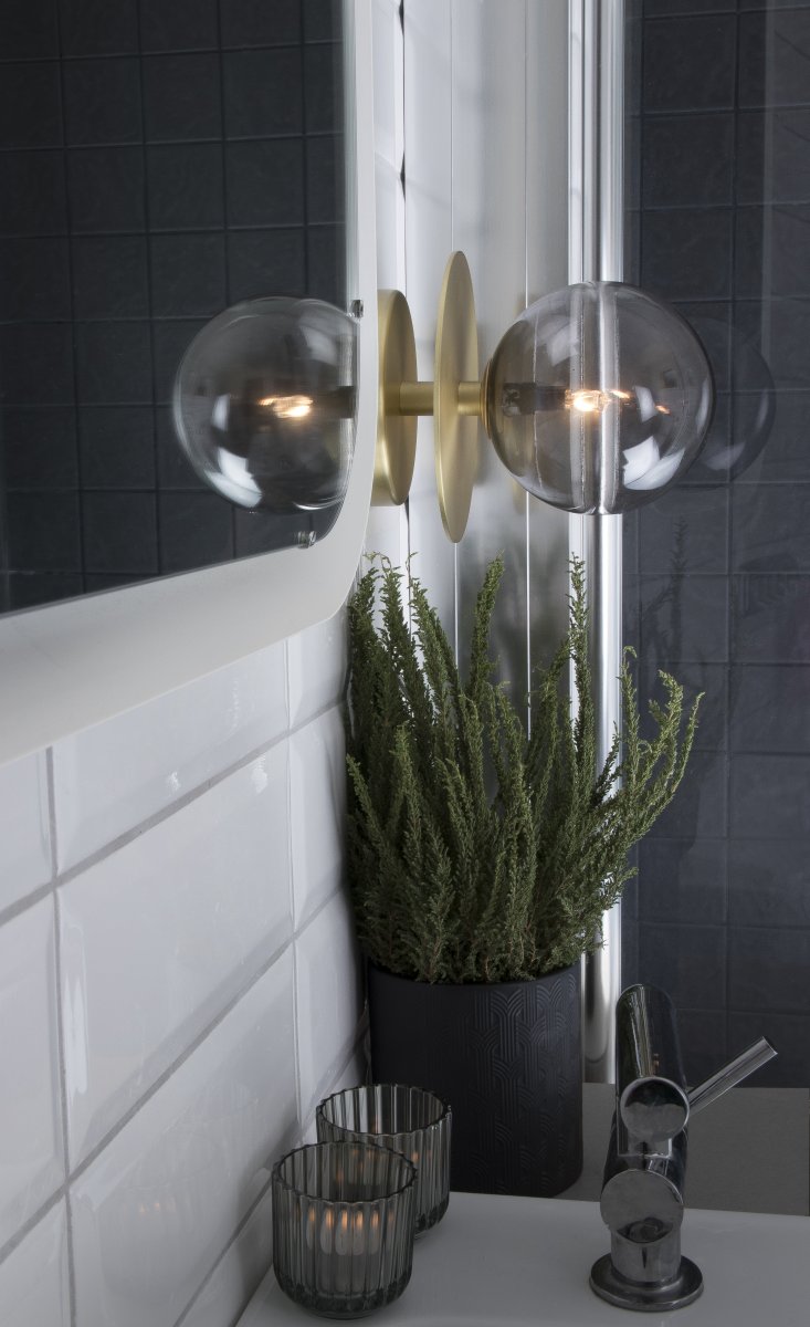 Art Deco Ø16 Laiton brossé/fumé lampe de salle de bain De Globen Lighting - Fabriqué en métal, il est doté d'un abat-jour en verre fumé qui diffuse une lumière éclatante dans la pièce.