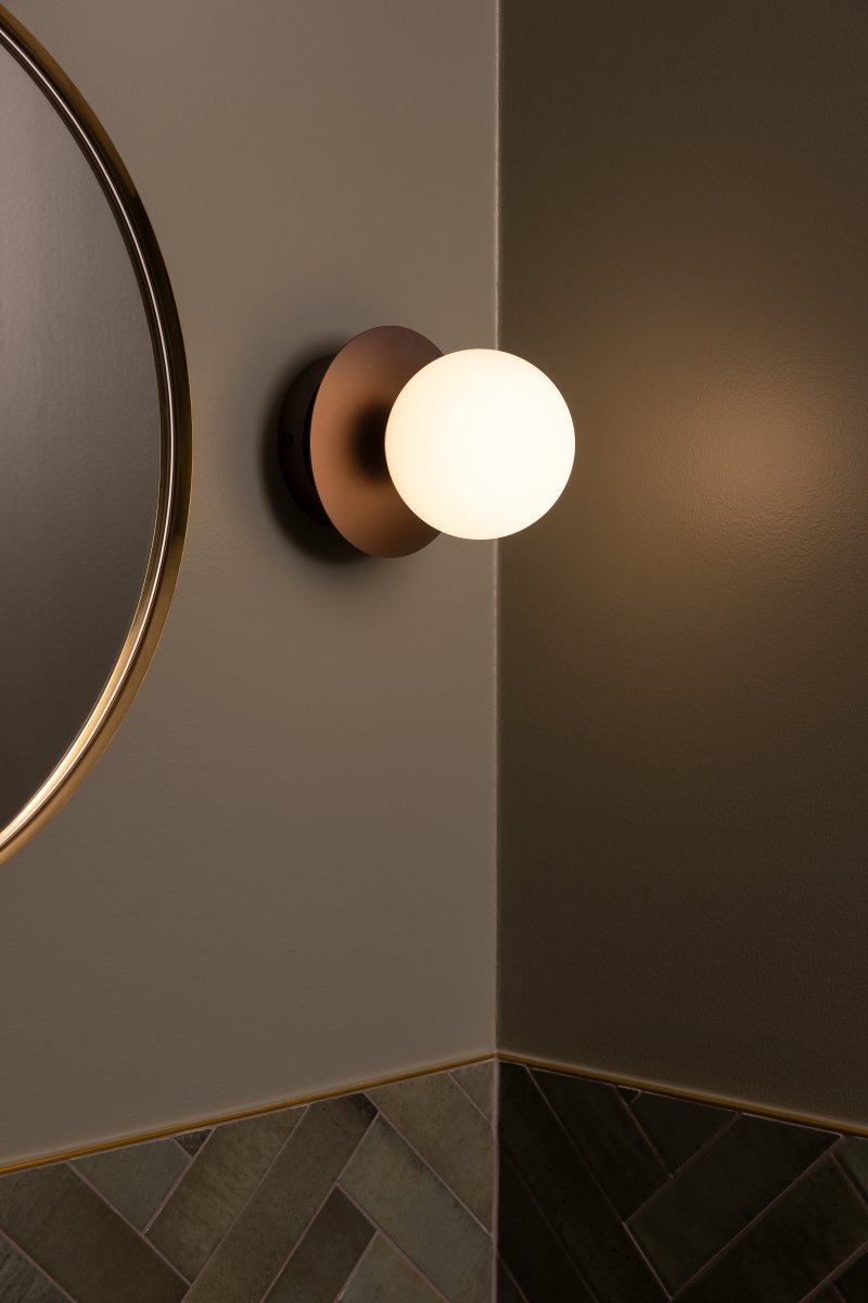Art Deco Ø16 Bronze/blanc lampe de salle de bain De Globen Lighting - Fabriquée en métal, elle est dotée d'un abat-jour en verre blanc qui diffuse une lumière agréable dans la pièce.