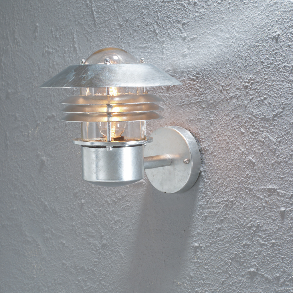 Modena Acier galvanisé lampe d’extérieur De Konstsmide - Avec son toit protecteur et son design élégant, il offre une lumière agréable et dirigée, idéale pour créer une atmosphère extérieure sûre et accueillante.