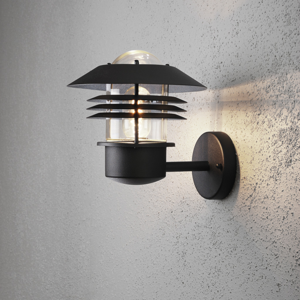 Modena Noir lampe d’extérieur De Konstsmide - Avec son toit protecteur et son design élégant, il offre une lumière agréable et dirigée, idéale pour créer une atmosphère extérieure sûre et accueillante.