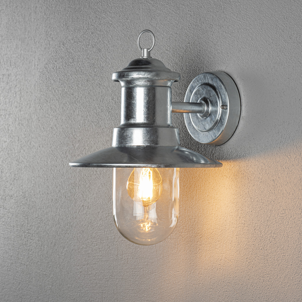 Napoli Galvanisé à chaud lampe d’extérieur De Konstsmide - Le design classique de la lampe avec un dôme en verre rond et un large abat-jour diffuse une lumière chaude et agréable, parfaite pour éclairer les entrées et les terrasses.