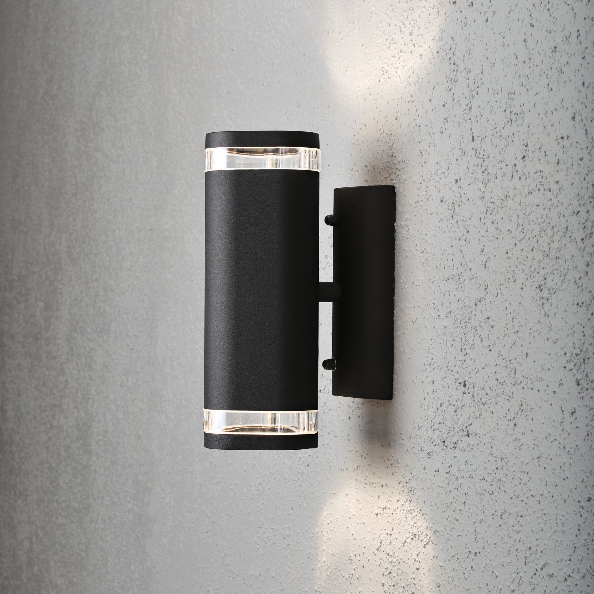 Modena II Noir lampe d’extérieur De Konstsmide - La lumi&egrave;re, diffus&eacute;e vers le haut et vers le bas, offre un &eacute;clairage d&eacute;coratif et efficace qui met en valeur la fa&ccedil;ade et cr&eacute;e une ambiance chaleureuse dans le jardin.