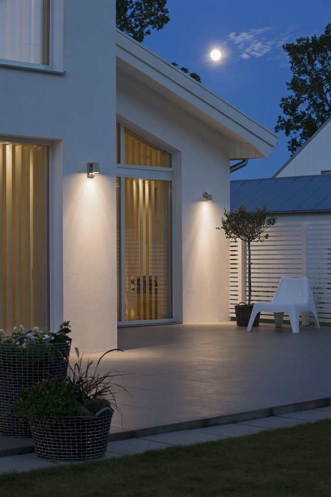 Modena Argent lampe d’extérieur De Konstsmide - Le design élégant et moderne de la lampe s'intègre dans n'importe quelle façade et s'allume automatiquement lorsqu'elle détecte un mouvement, offrant une sécurité supplémentaire dans les entrées et les allées.