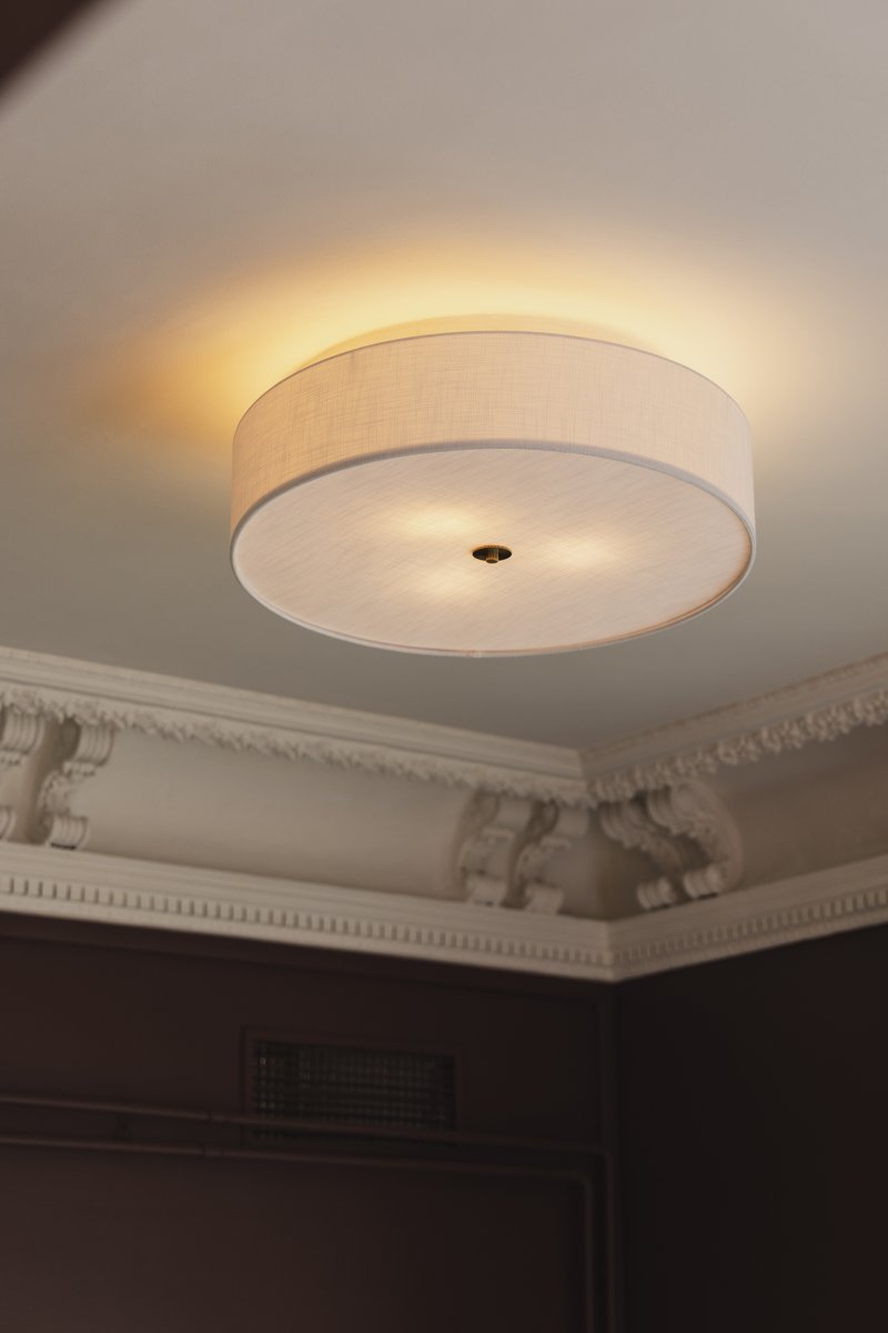 Noah Ø65 Blanc plafonnier De Globen Lighting - Un diffuseur assorti en lin blanc, placé à sa base, adoucit la lumière et crée une ambiance douce et diffuse.