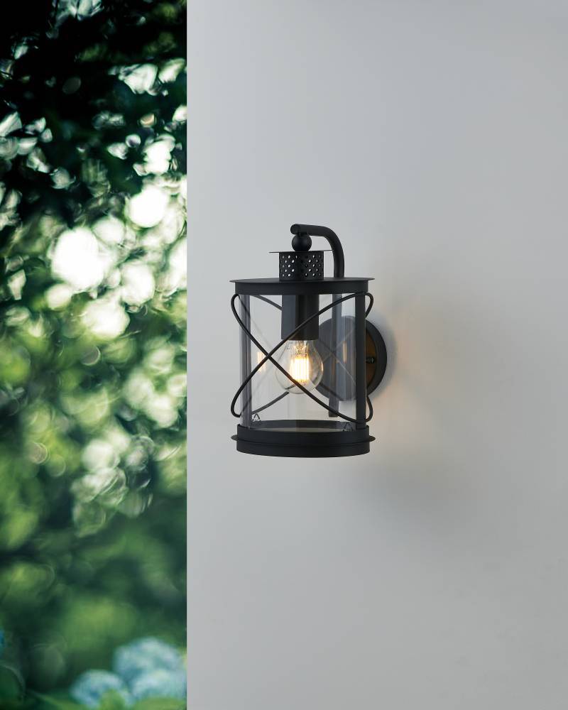 Hilburn Noir lampe d’extérieur De Eglo - Cette applique murale a un design de lanterne classique qui combine un cadre noir robuste avec du verre transparent, ce qui la rend idéale pour l'éclairage extérieur.