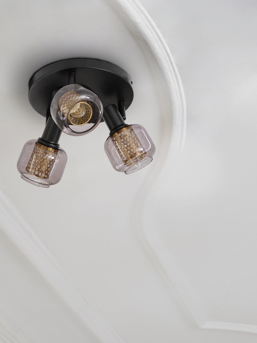 Firefly 3 Noir spot De Ledvance - De r&ouml;rliga spotlightsen med sk&auml;rmar av gr&aring;tonat glas i kombination med de guldiga detaljh&ouml;ljet som omfamnar ljusk&auml;llorna bidrar med en elegans till rummet.