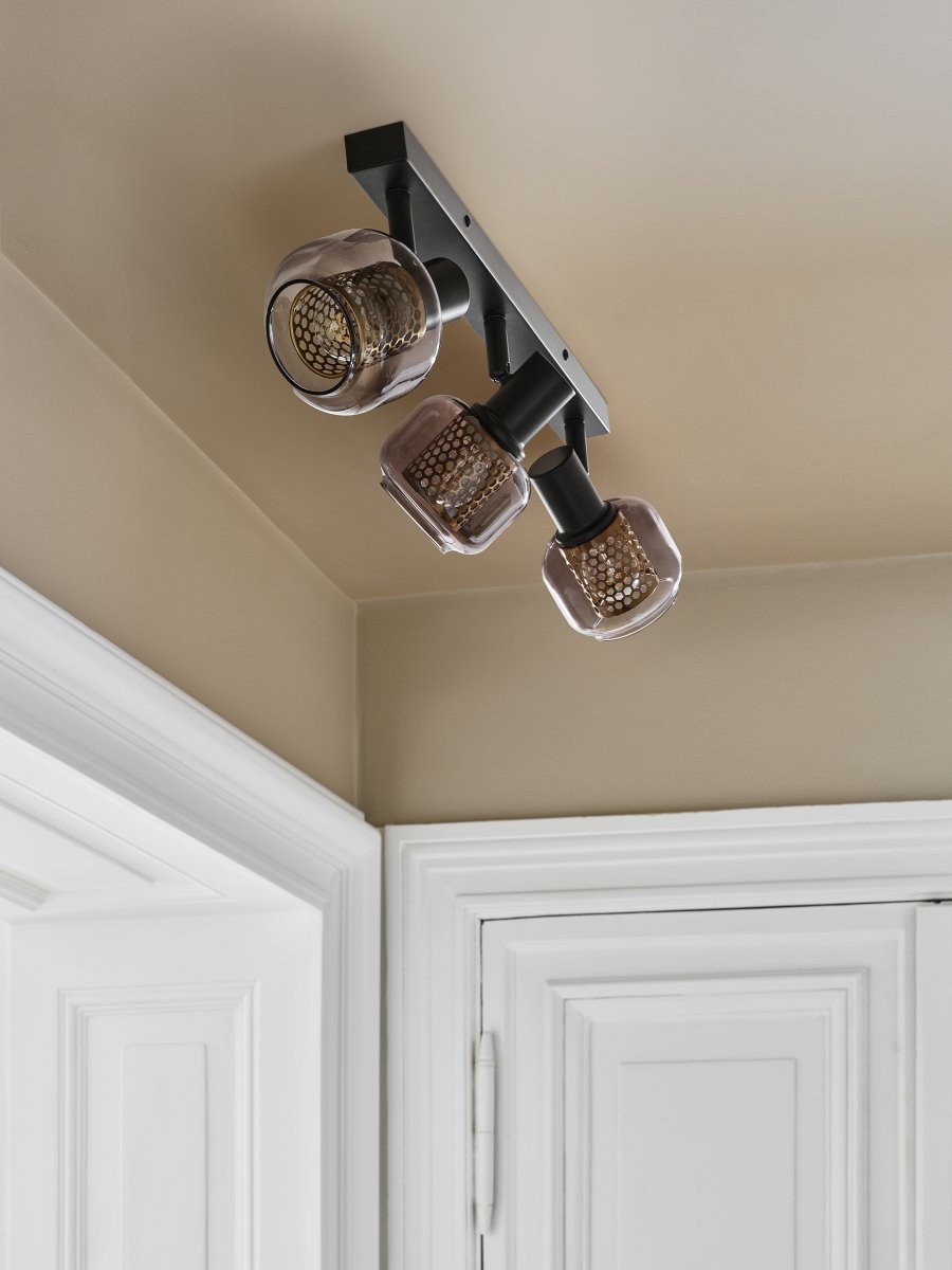 Firefly 3 Noir spot De Ledvance - De r&ouml;rliga spotlightsen med sk&auml;rmar av gr&aring;tonat glas i kombination med de guldiga detaljh&ouml;ljet som omfamnar ljusk&auml;llorna bidrar med en elegans till rummet.