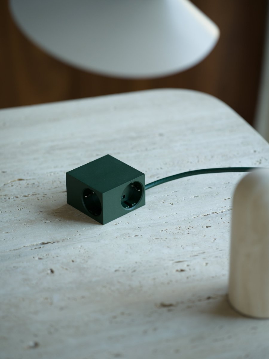 Cuboid Vert foncé De Kord - Plusieurs options de montage&nbsp;: fixez la prise directement sur des surfaces m&eacute;talliques gr&acirc;ce aux c&ocirc;t&eacute;s magn&eacute;tiques, utilisez le support fourni avec surface de friction pour une fixation stable sur une table, ou fixez-la au mur avec du ruban adh&eacute;sif 3M pour une prise de courant discr&egrave;te et facilement accessible.